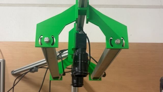 Machine vision verlichting in de praktijk: schuin geplaatste balkverlichting en een rood ringlicht rond de cameralens